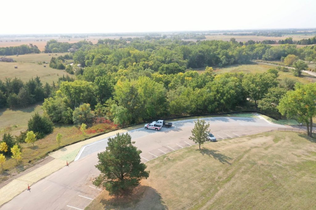 Arial View of a Road with Parking Spaces within a Moderated Wooded Landscape