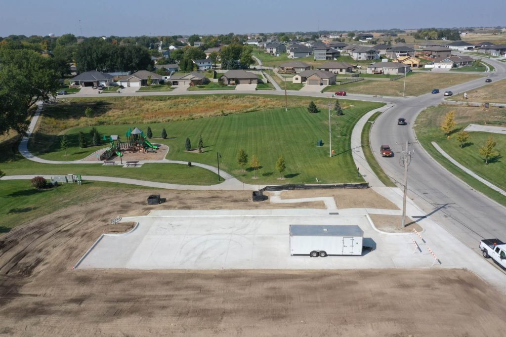 Small City Park Alongside a Street with a New Concrete Parking Lot