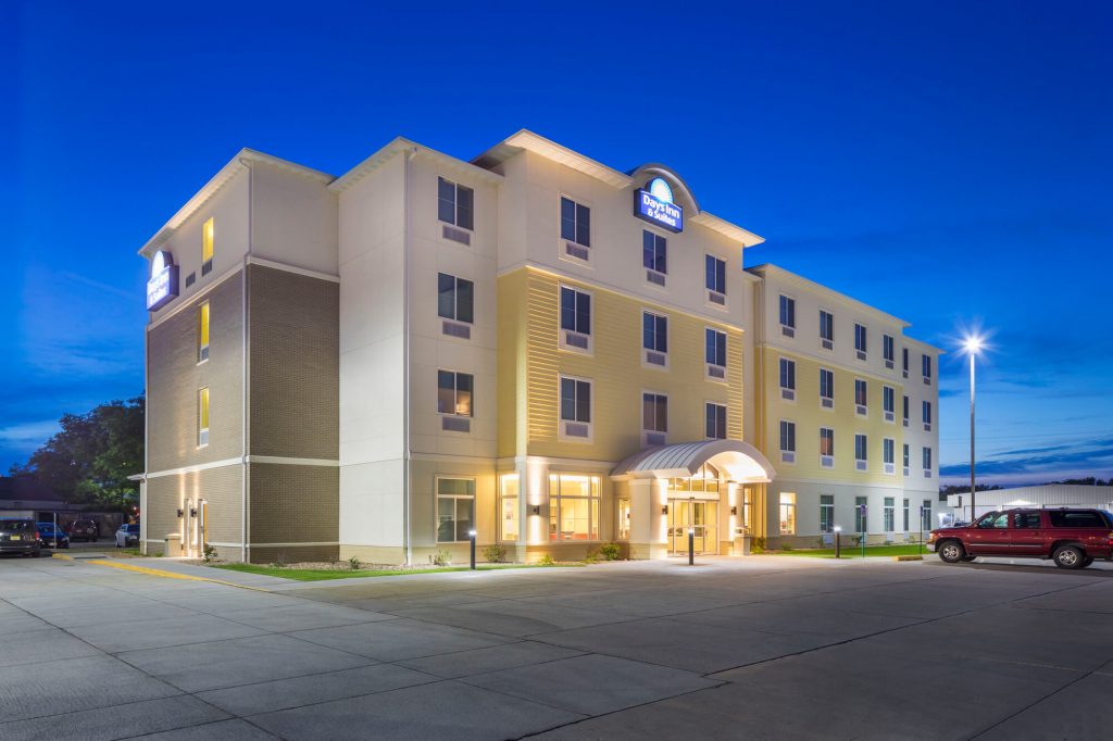 Facade of a four story, yellow hotel building at night